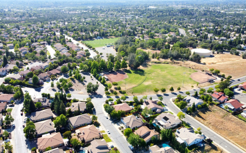 Aerial view of a suburban neighborhood next to an open park