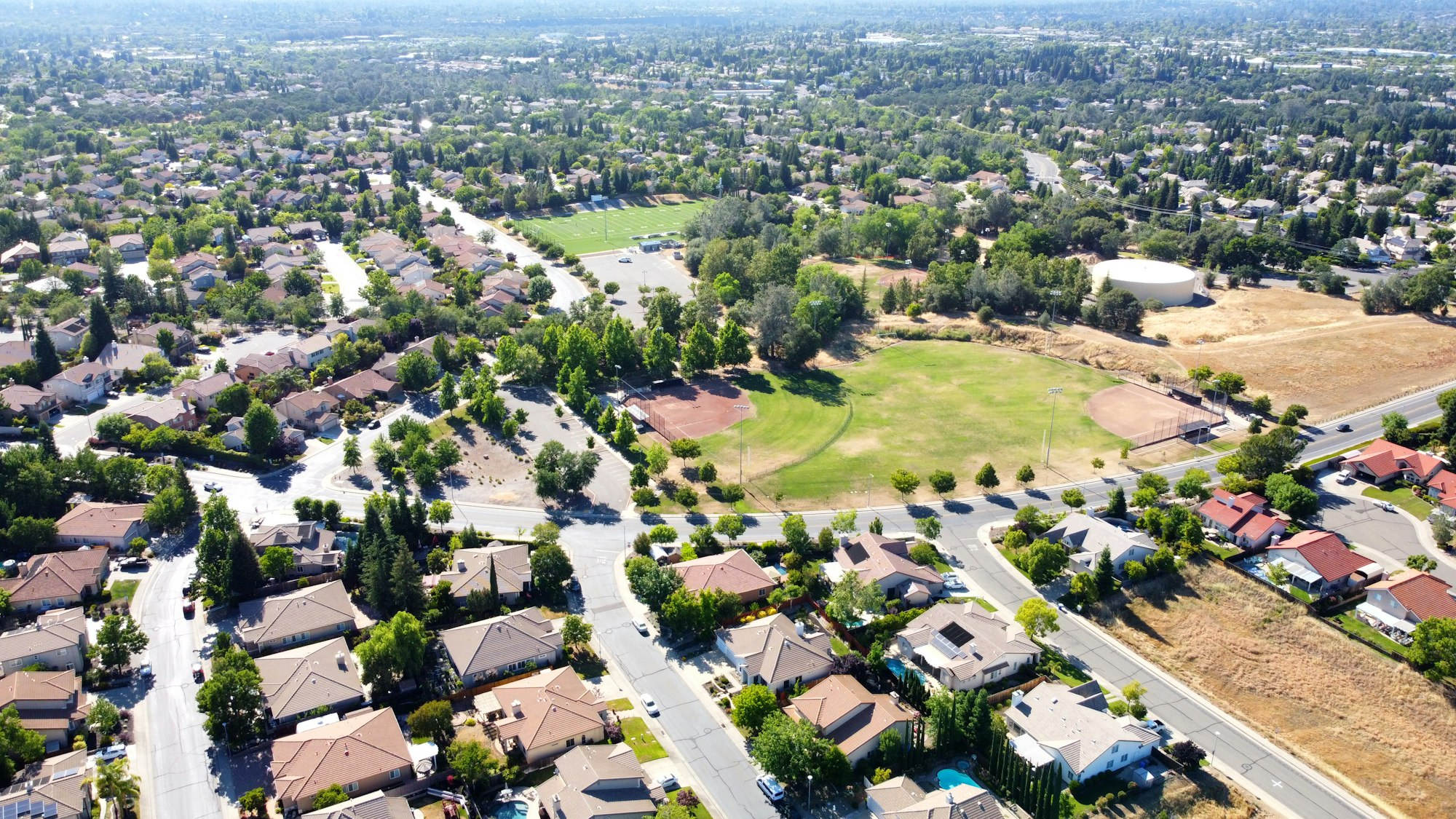 Aerial view of a suburban neighborhood next to an open park