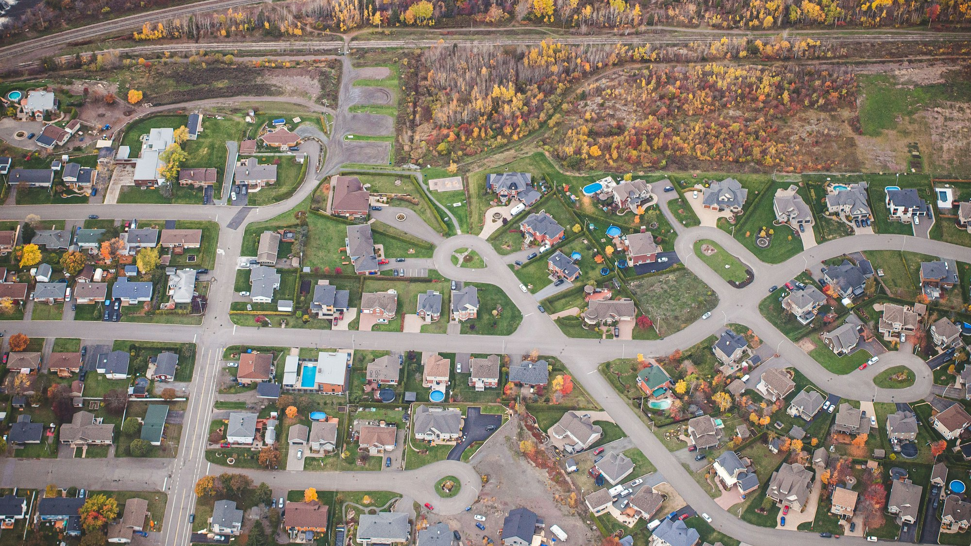 Aerial view of a residential neighborhood with curving streets in autumn